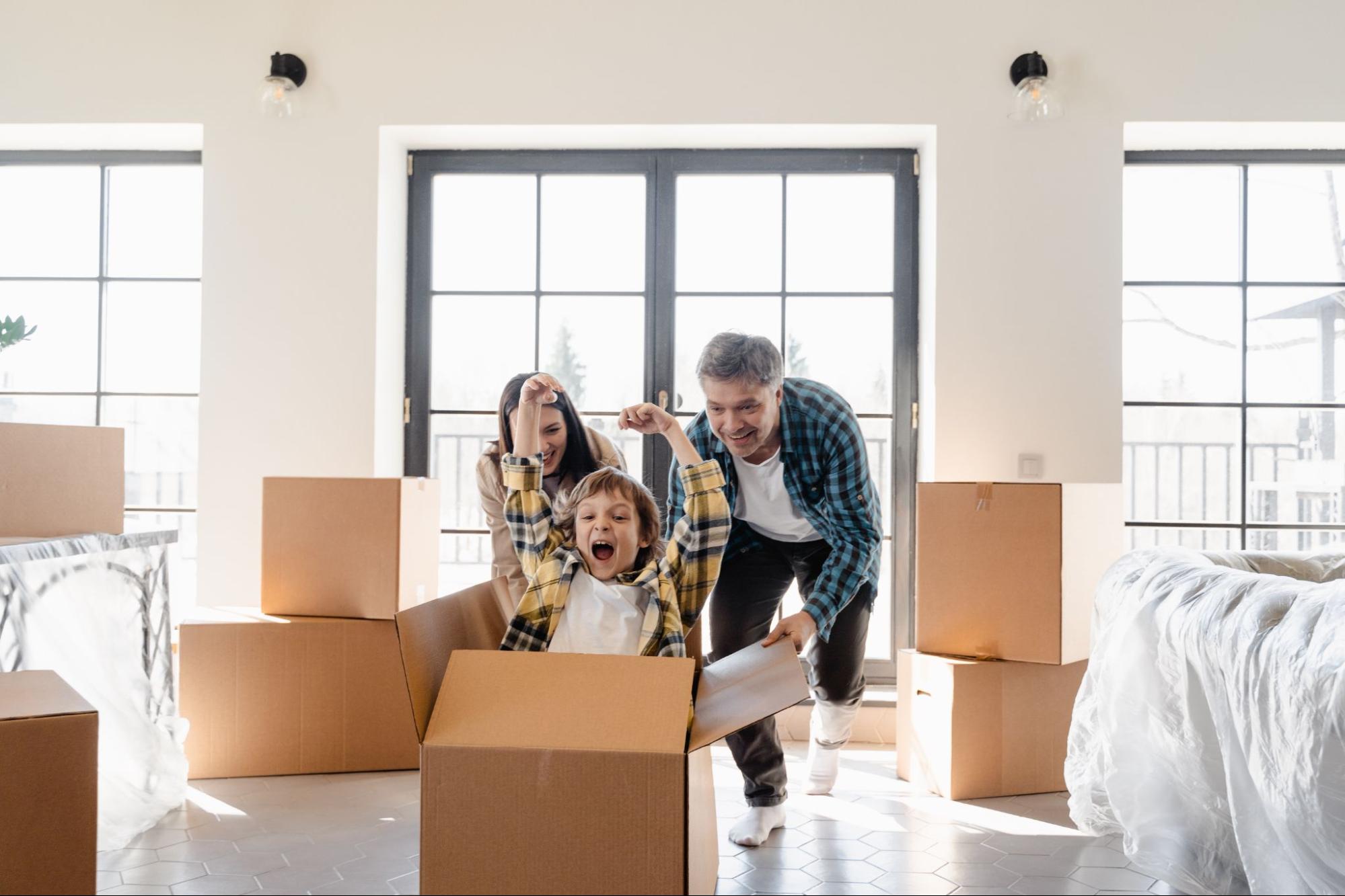 Happy family with cheering child riding in moving box